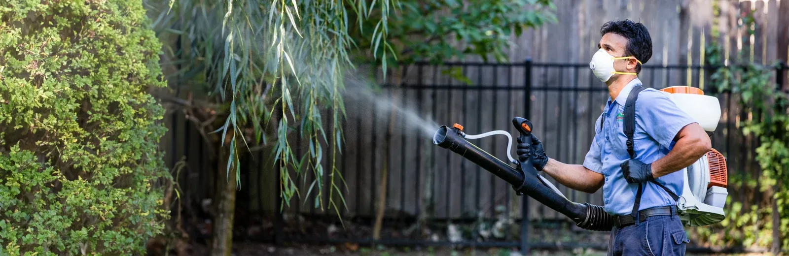 Dial Environmental technician spraying outside for mosquitoes